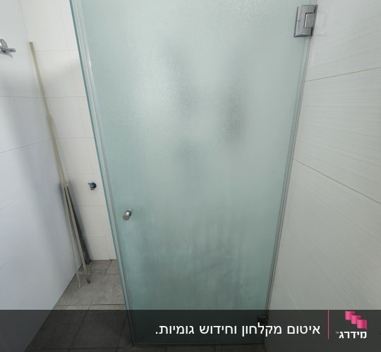מקלחון חזית מזכוכית חלבית עם צירי מתכת בחדר רחצה